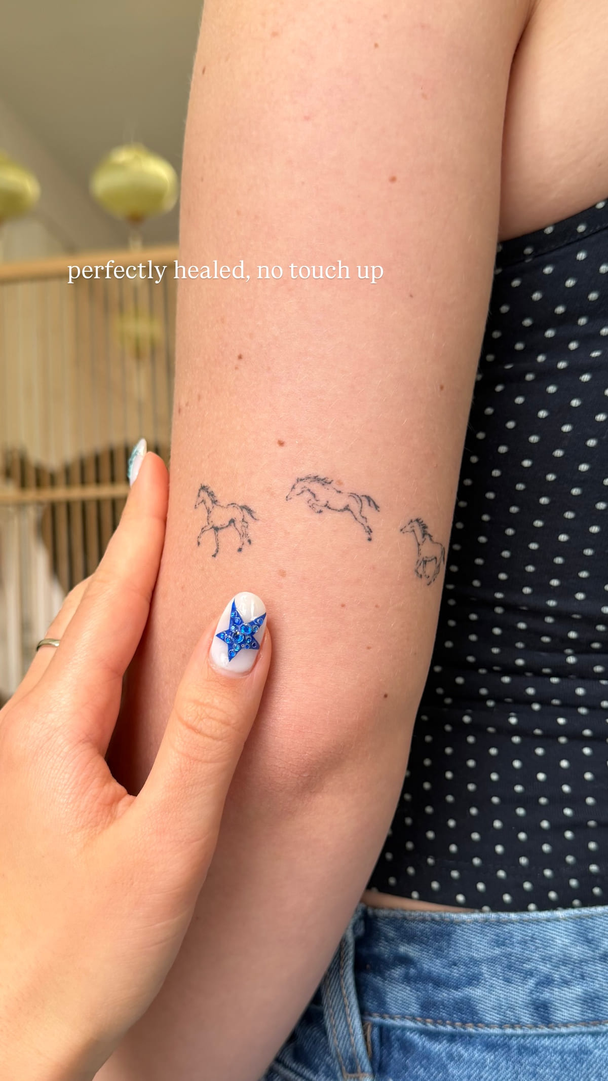 Three tiny running horses on an inner forearm, healed fine line tattoo