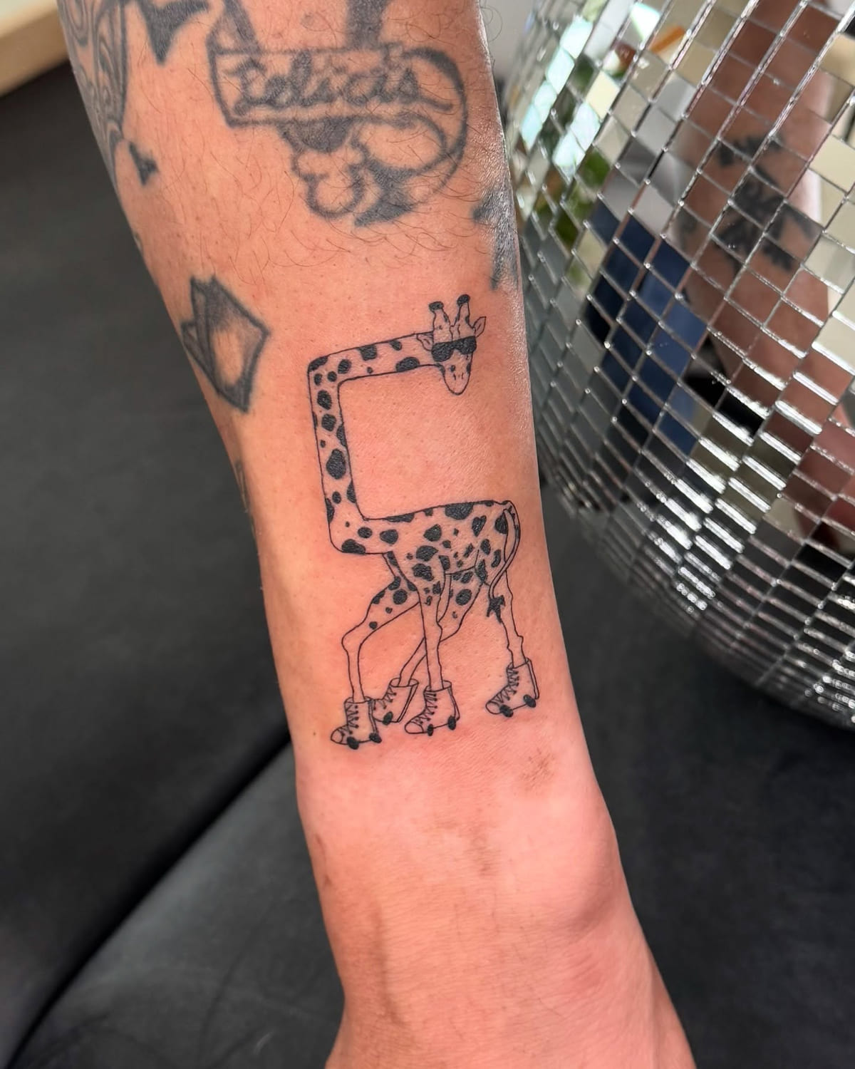 Giraffe in sunglasses on roller skates, fine line tattoo