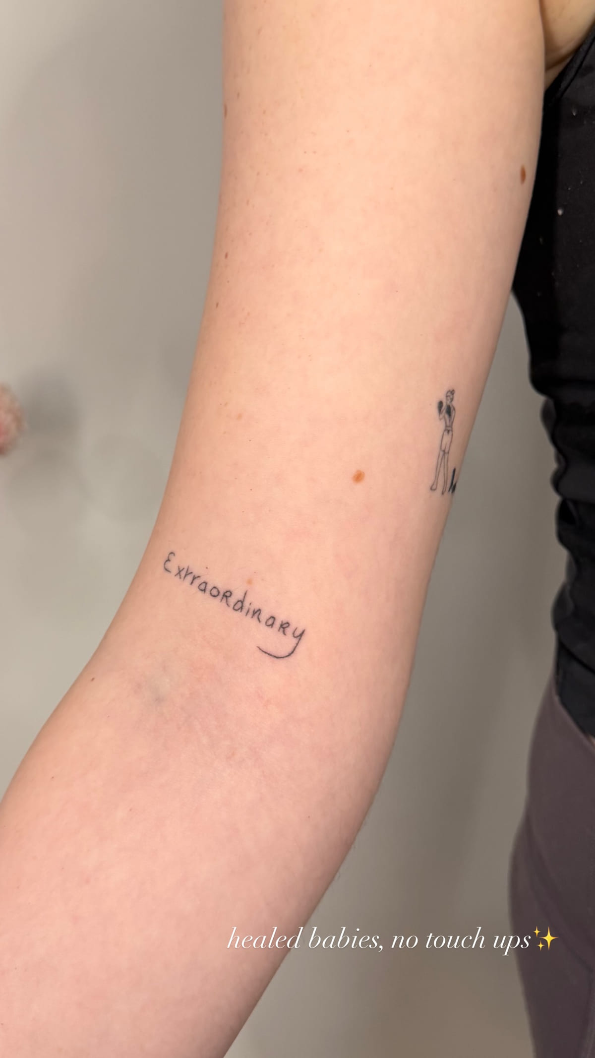 Small script word on a forearm, healed fine line tattoo