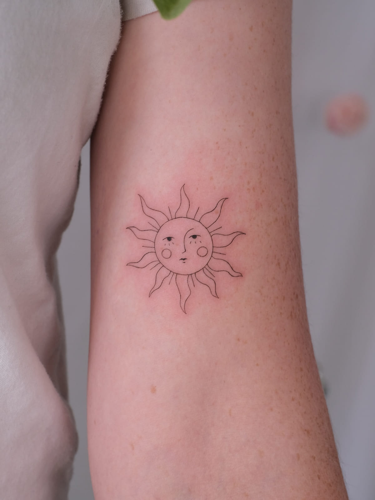 Sun with a gentle face, fine line tattoo
