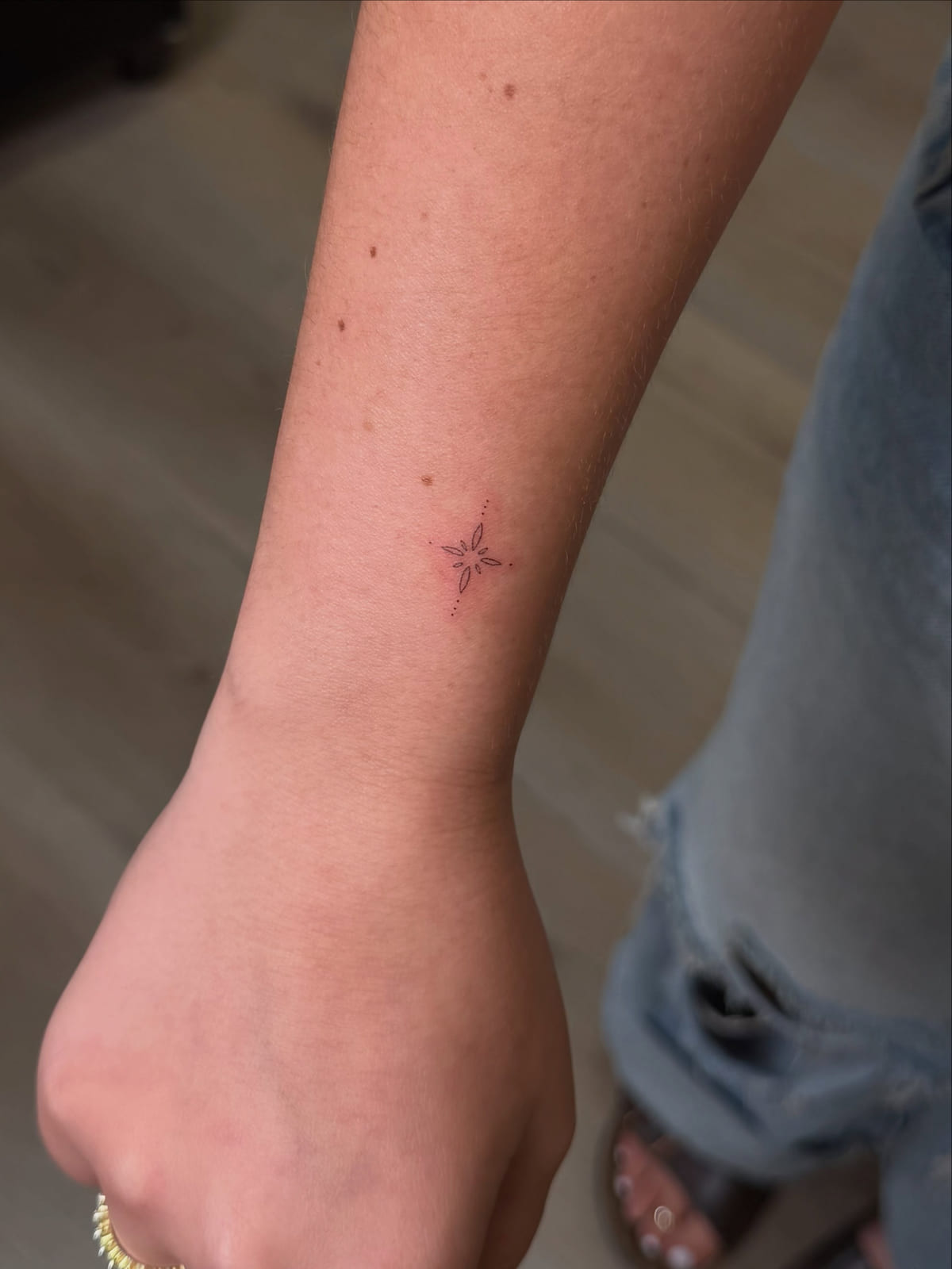 Tiny four point star, fine line tattoo
