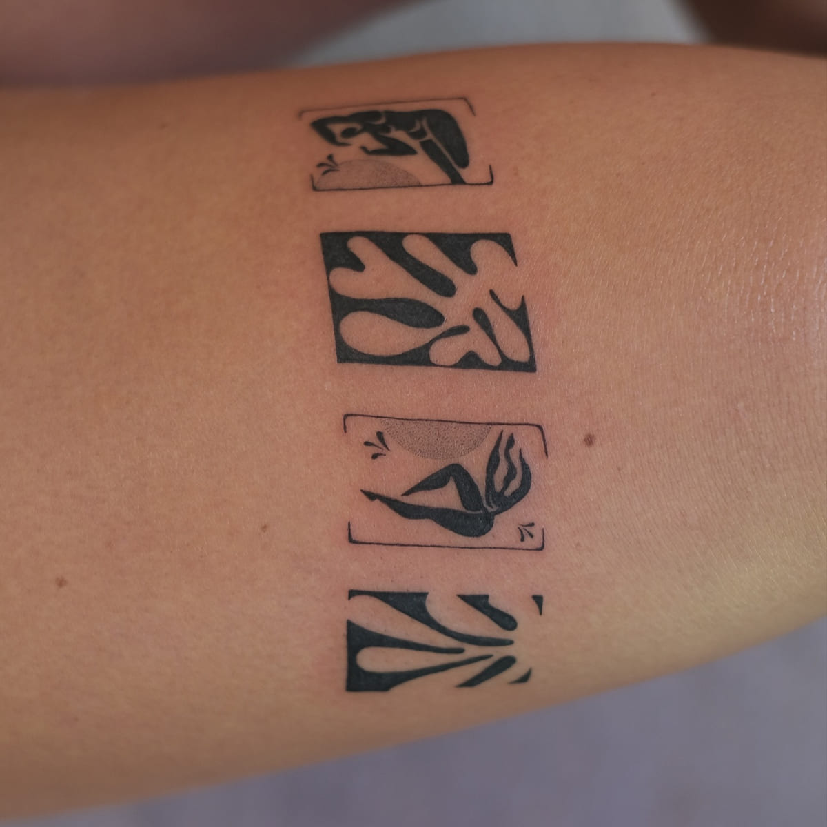 Band of four Matisse cut outs above the knee: leaf forms and blue nudes in solid black, another view