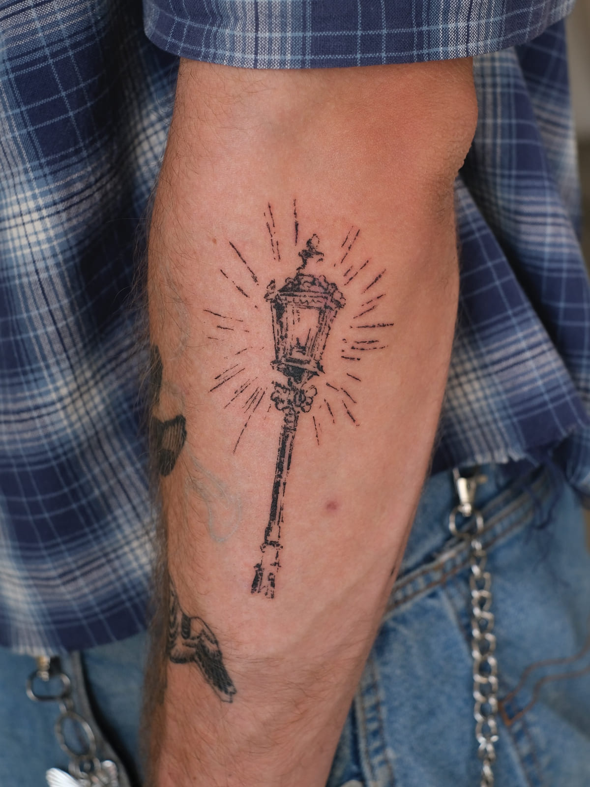 Glowing street lantern on a tall post, fine line tattoo