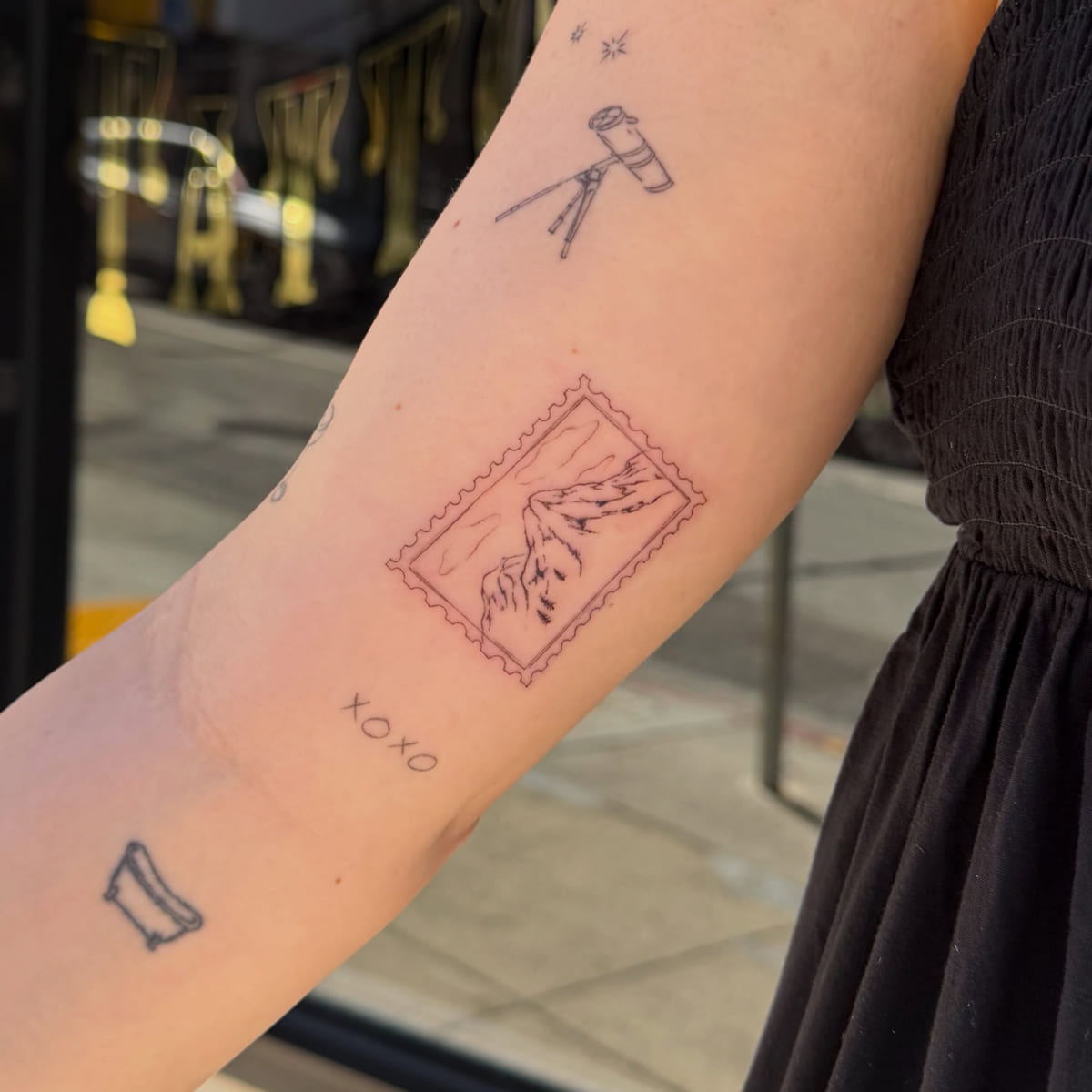 Postage stamp with two hands, fine line tattoo