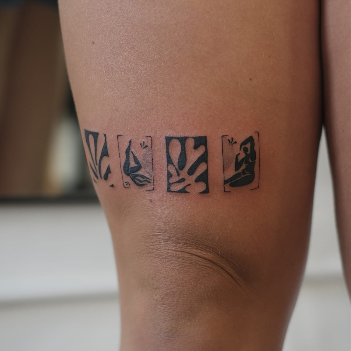Band of four Matisse cut outs above the knee: leaf forms and blue nudes in solid black, another view