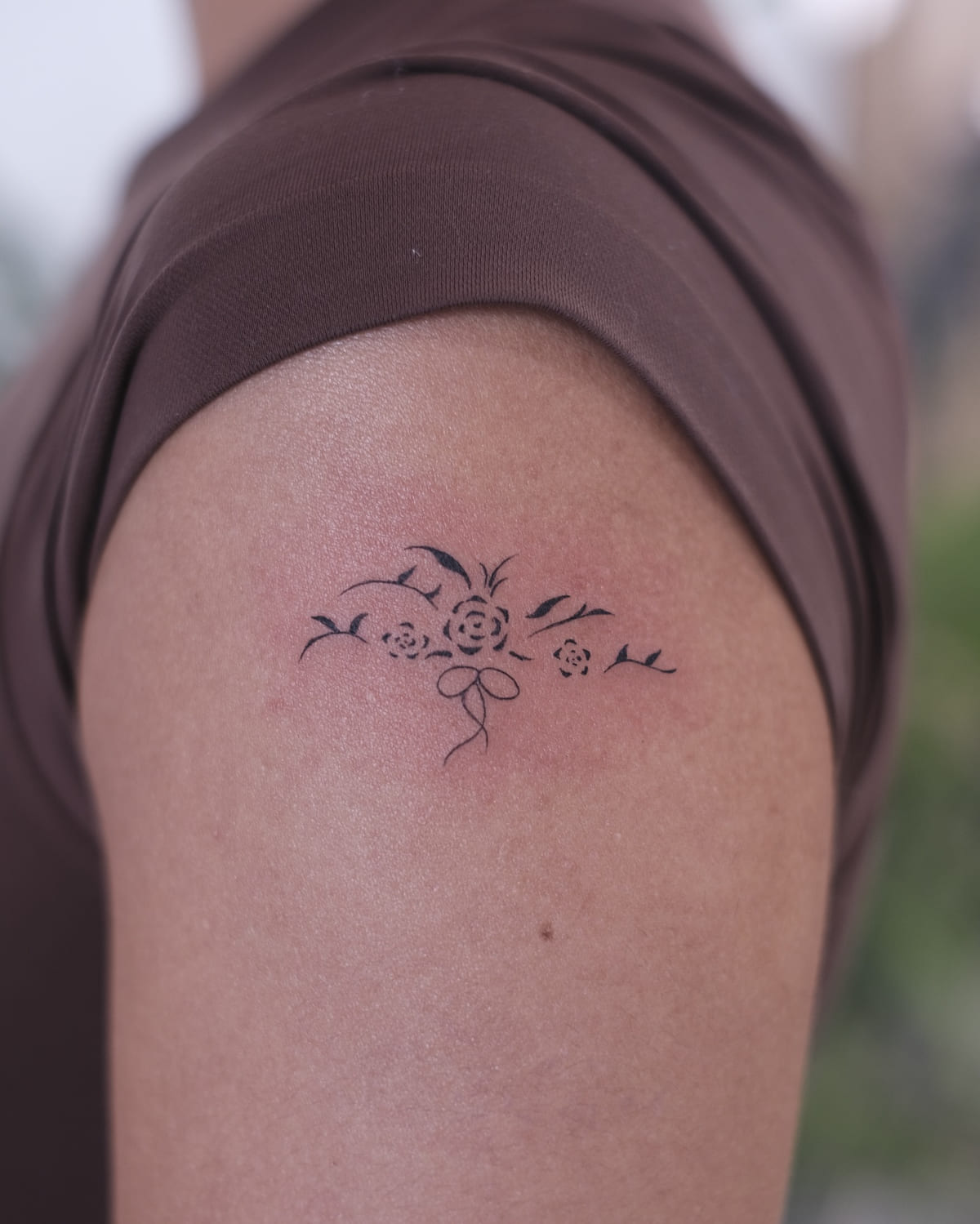 Small floral ornament with a bow, fine line tattoo