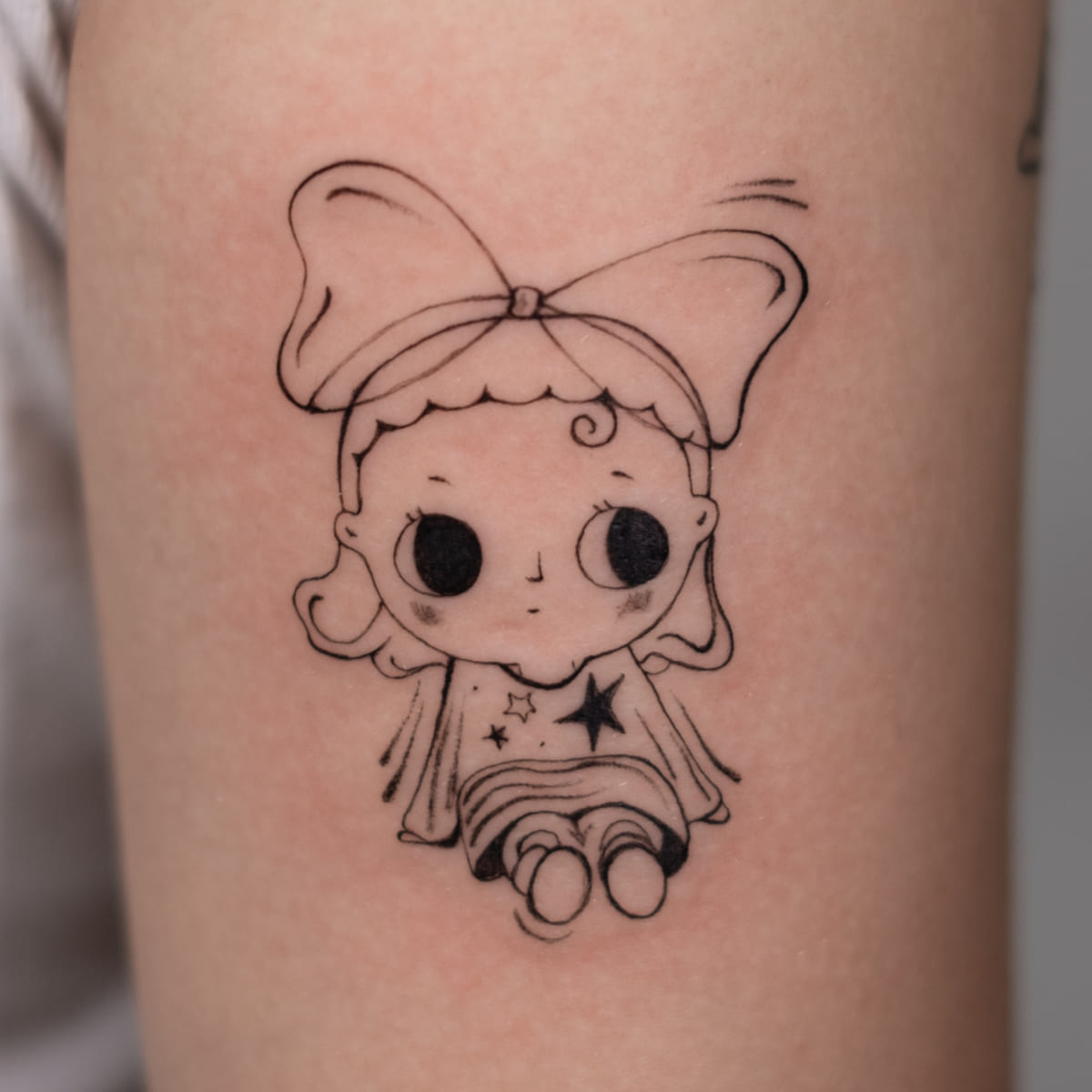 Doll with a bow, fine line tattoo