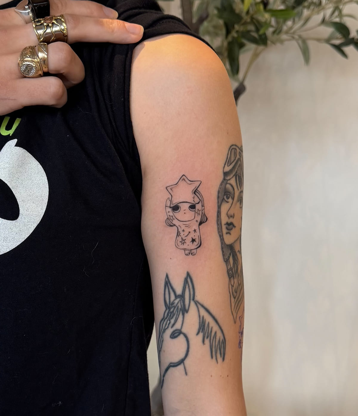 Little character with a star shaped head, fine line tattoo