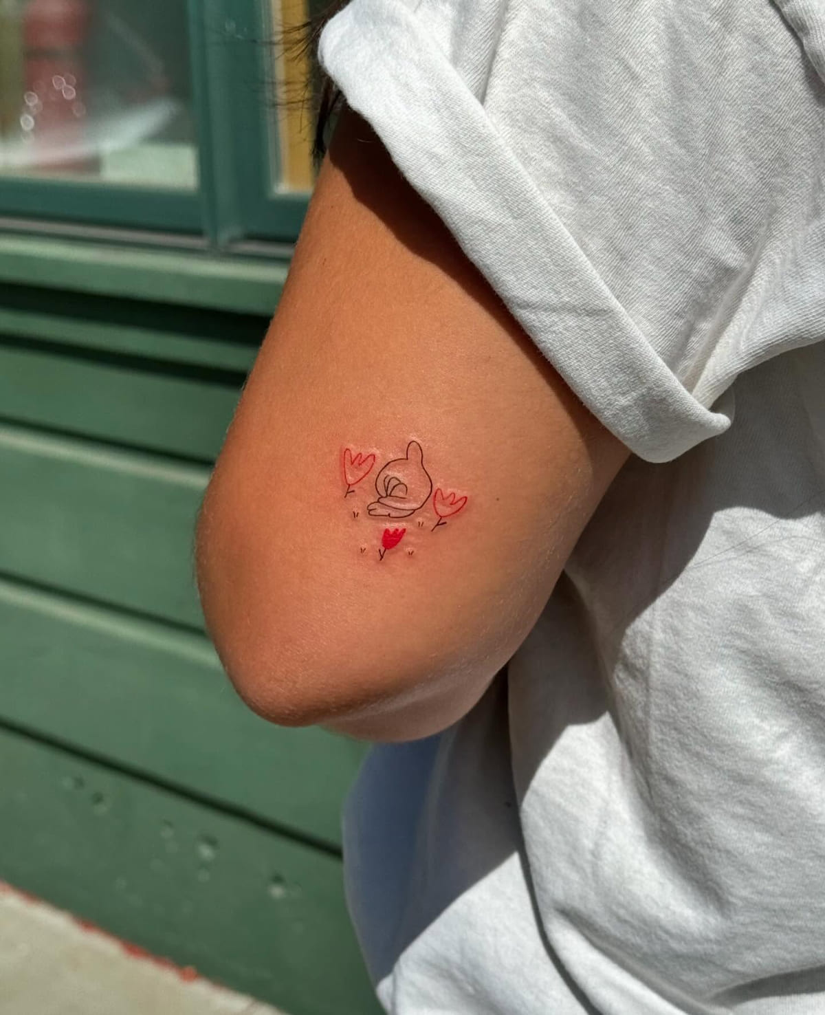 Small swan among red hearts, fine line tattoo