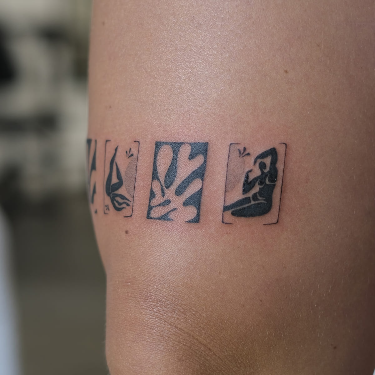 Band of four Matisse cut outs above the knee: leaf forms and blue nudes in solid black, another view