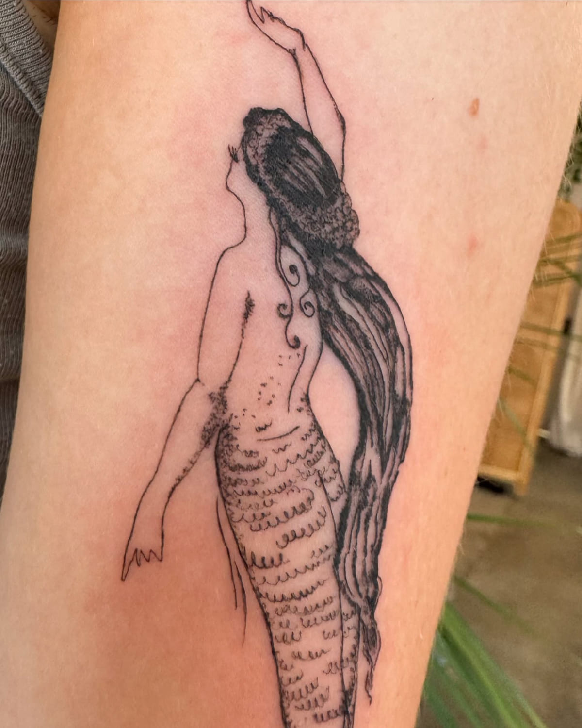 Mermaid seen from behind, reaching up, long hair and long tail, another view