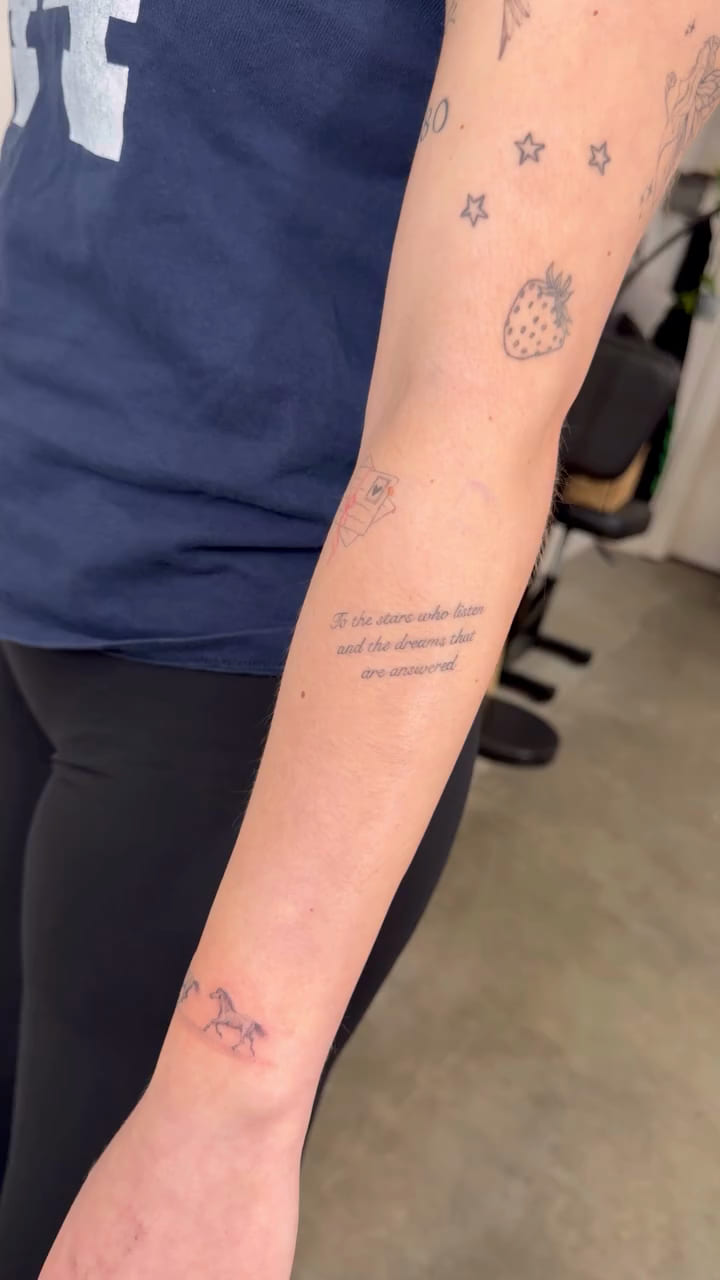 Three lines of fine script on a forearm, healed fine line tattoo