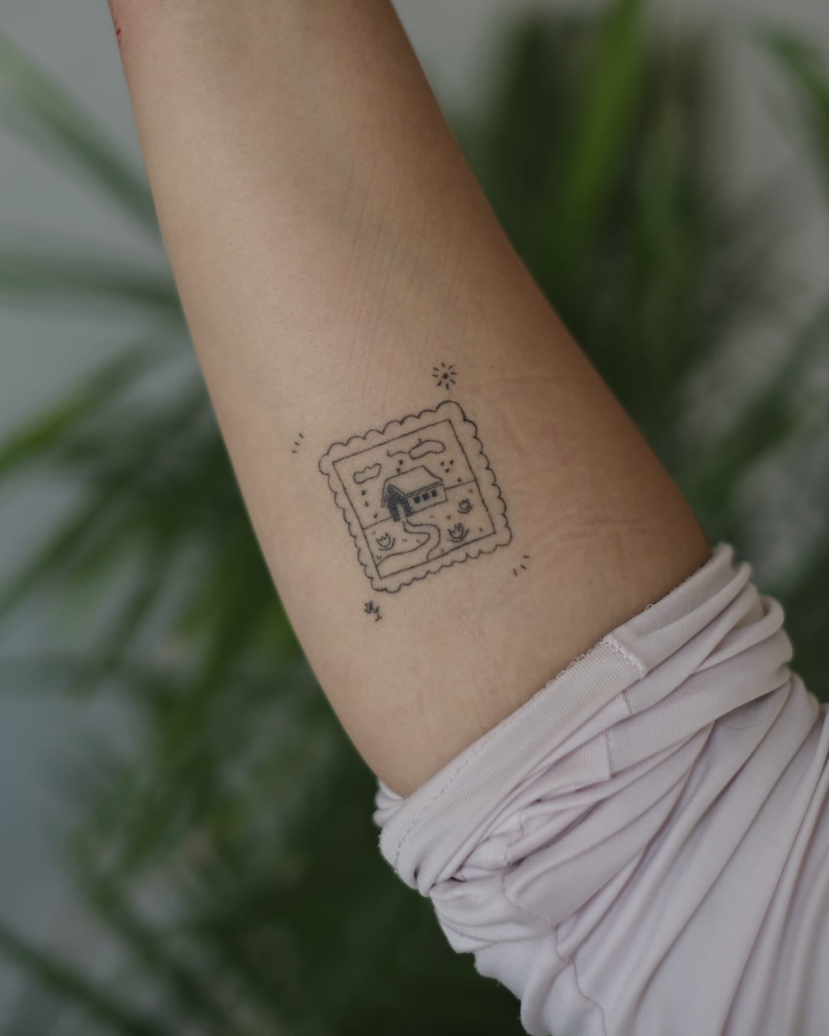 Postage stamp with a small house, healed fine line tattoo