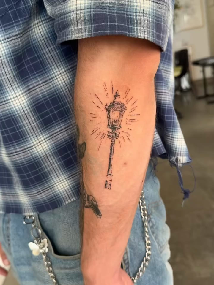 Glowing street lantern on a tall post, fine line tattoo