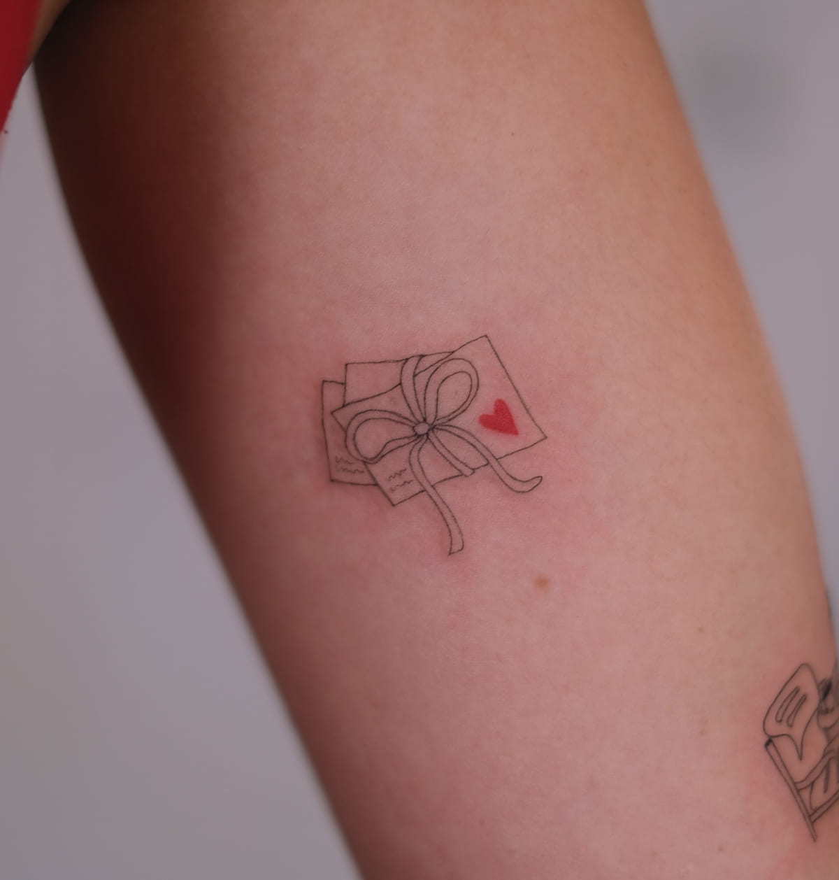 Stack of letters tied with a bow, one red heart, another view
