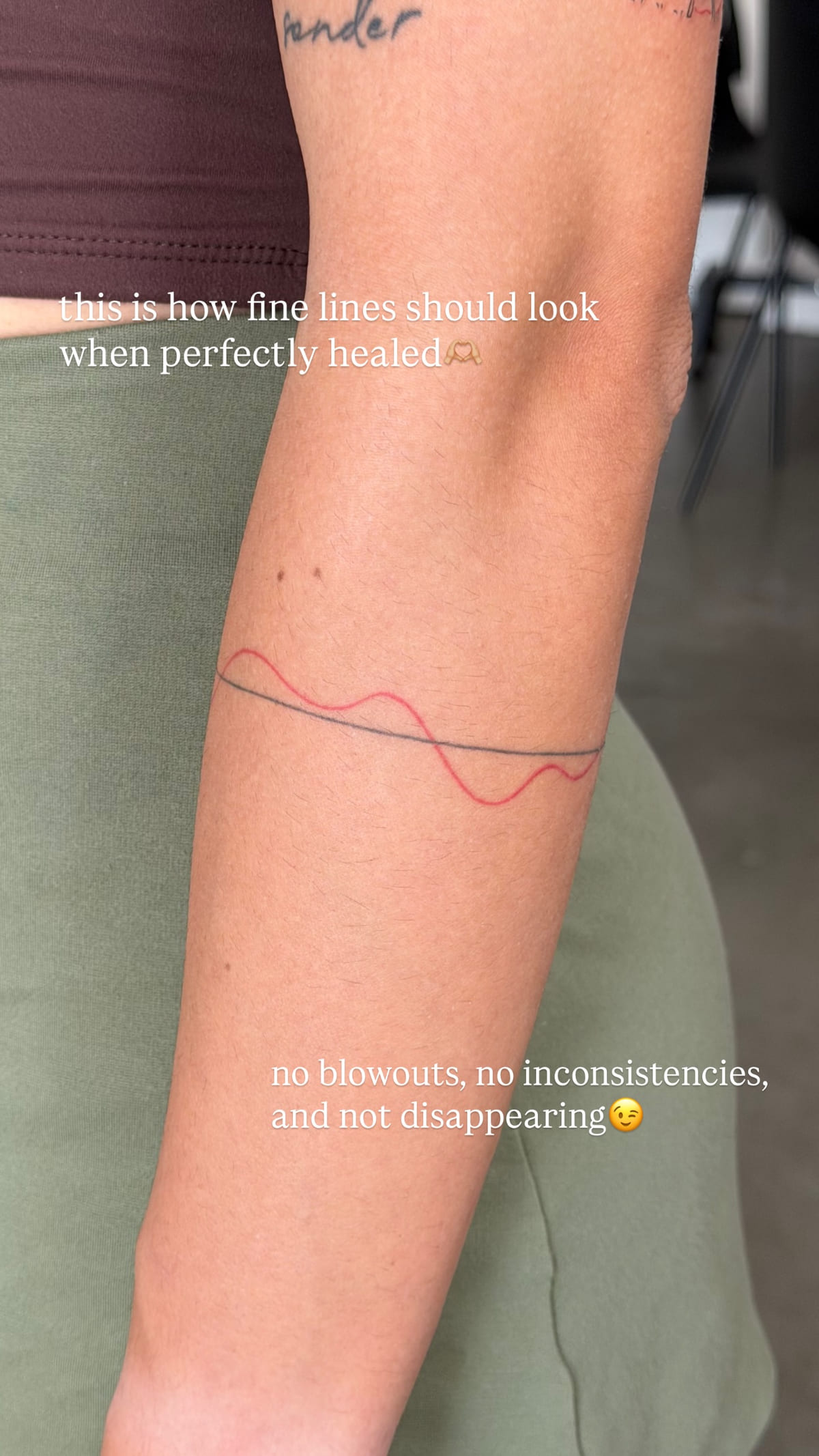 Thin armband of one black line and one red wave, healed fine line tattoo, healed