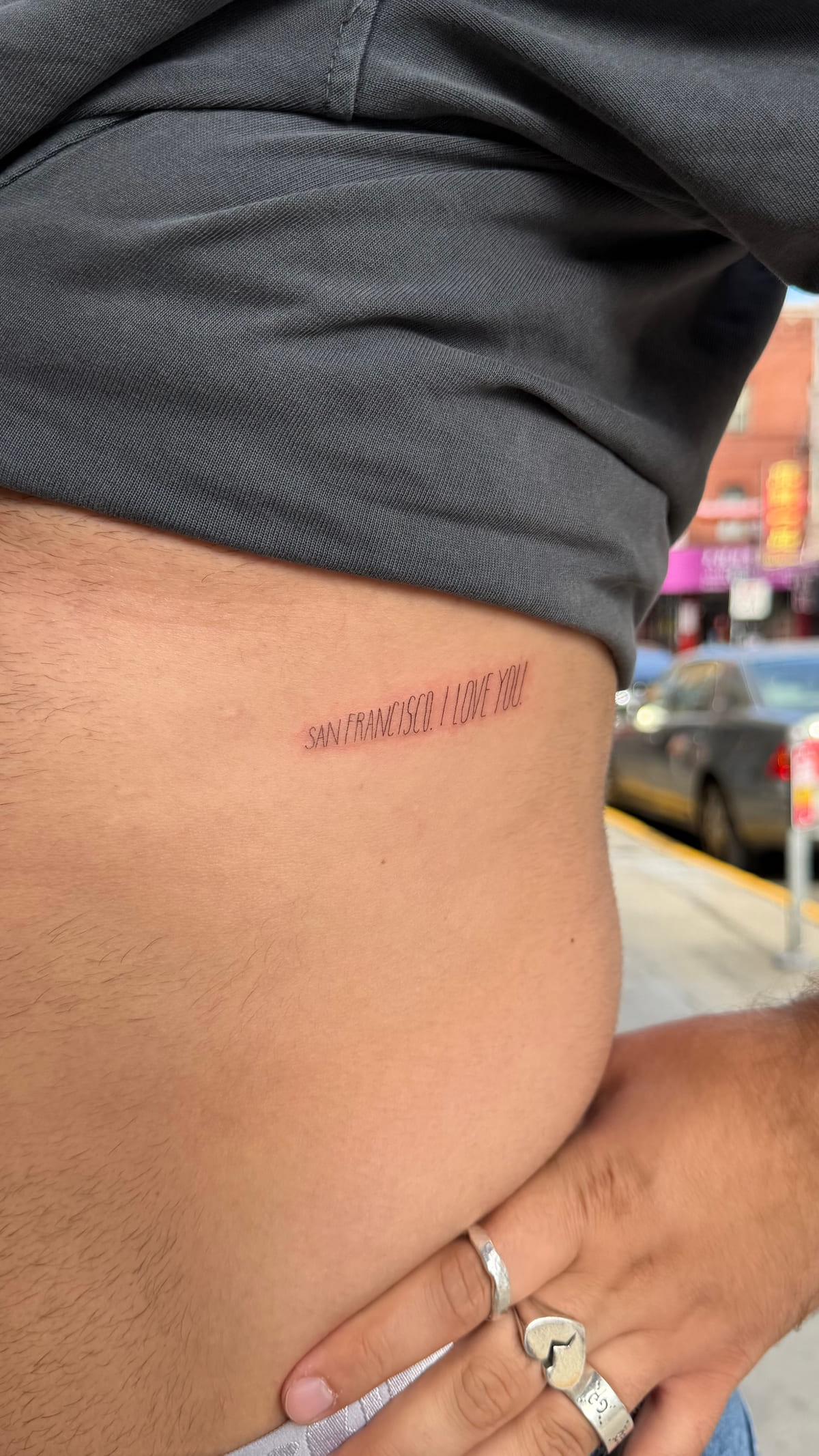 San Francisco I love you, red lettering on the ribs, fine line tattoo