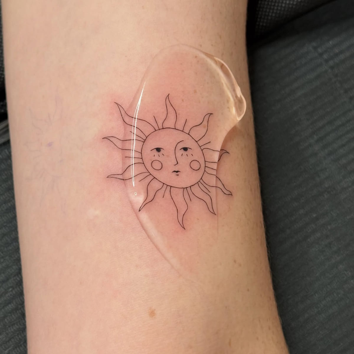 Sun with a face, fine line tattoo