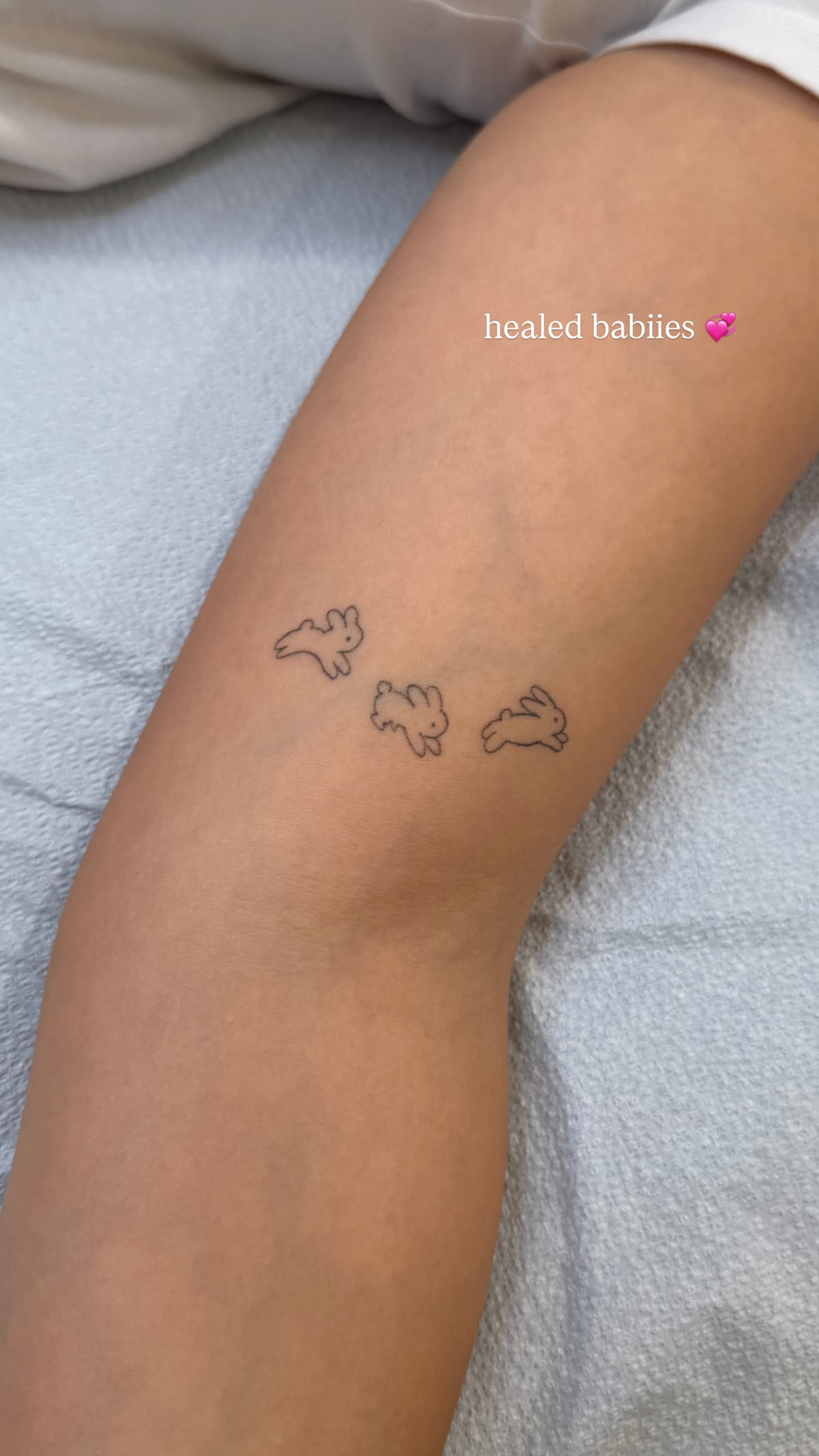 Three tiny running rabbit outlines, healed fine line tattoo, healed