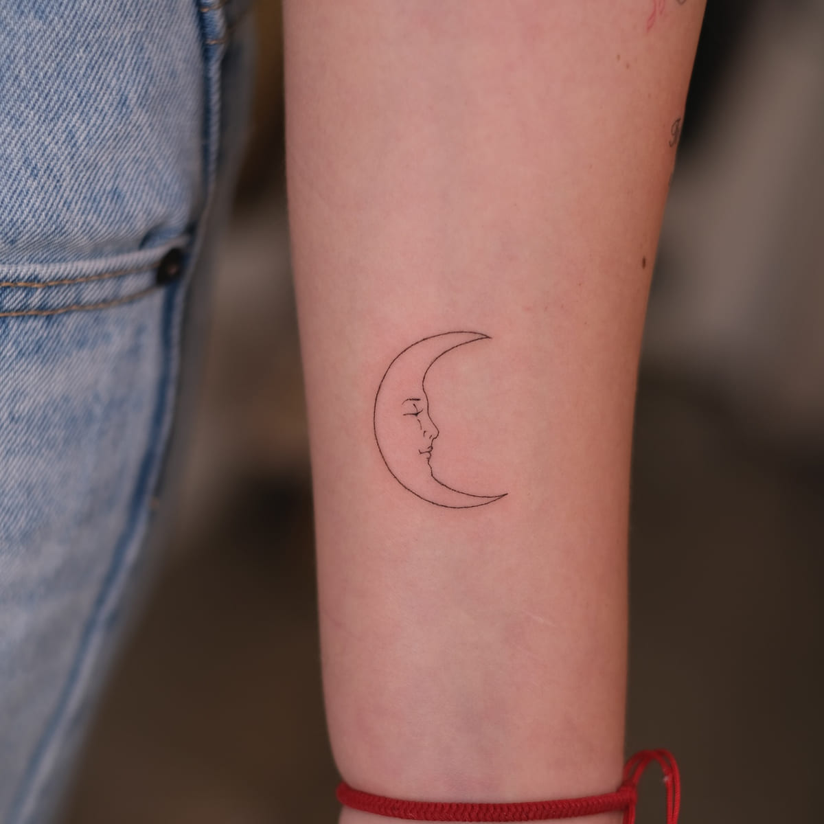 Crescent moon with a sleeping face, fine line tattoo