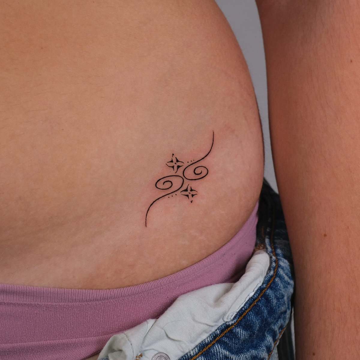 Swirl ornament with two sparkles, fine line tattoo
