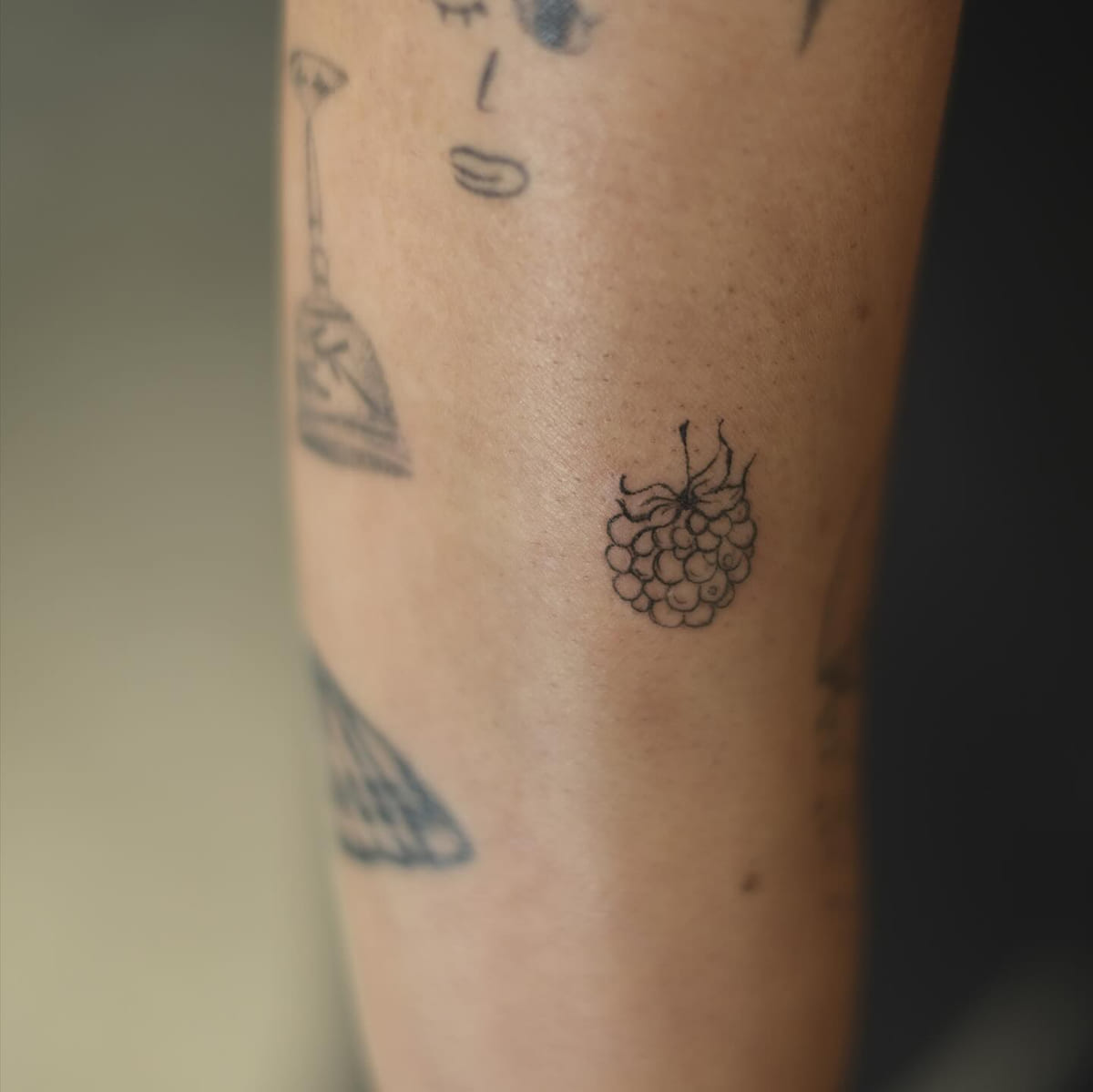 Tiny raspberry, fine line tattoo