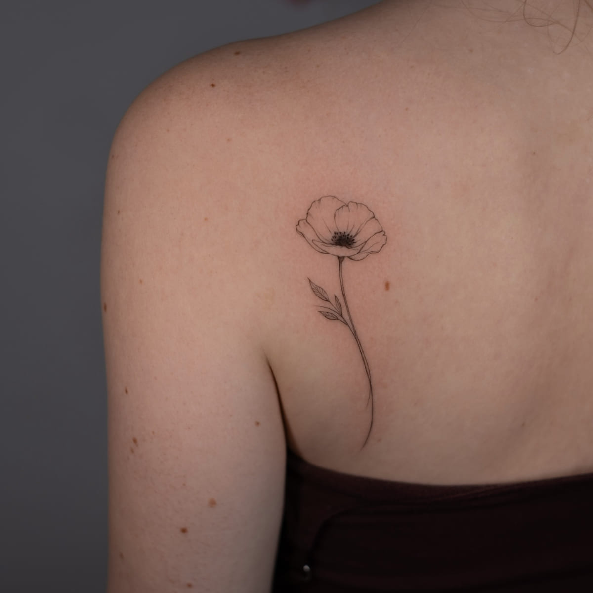 Single poppy, fine line tattoo