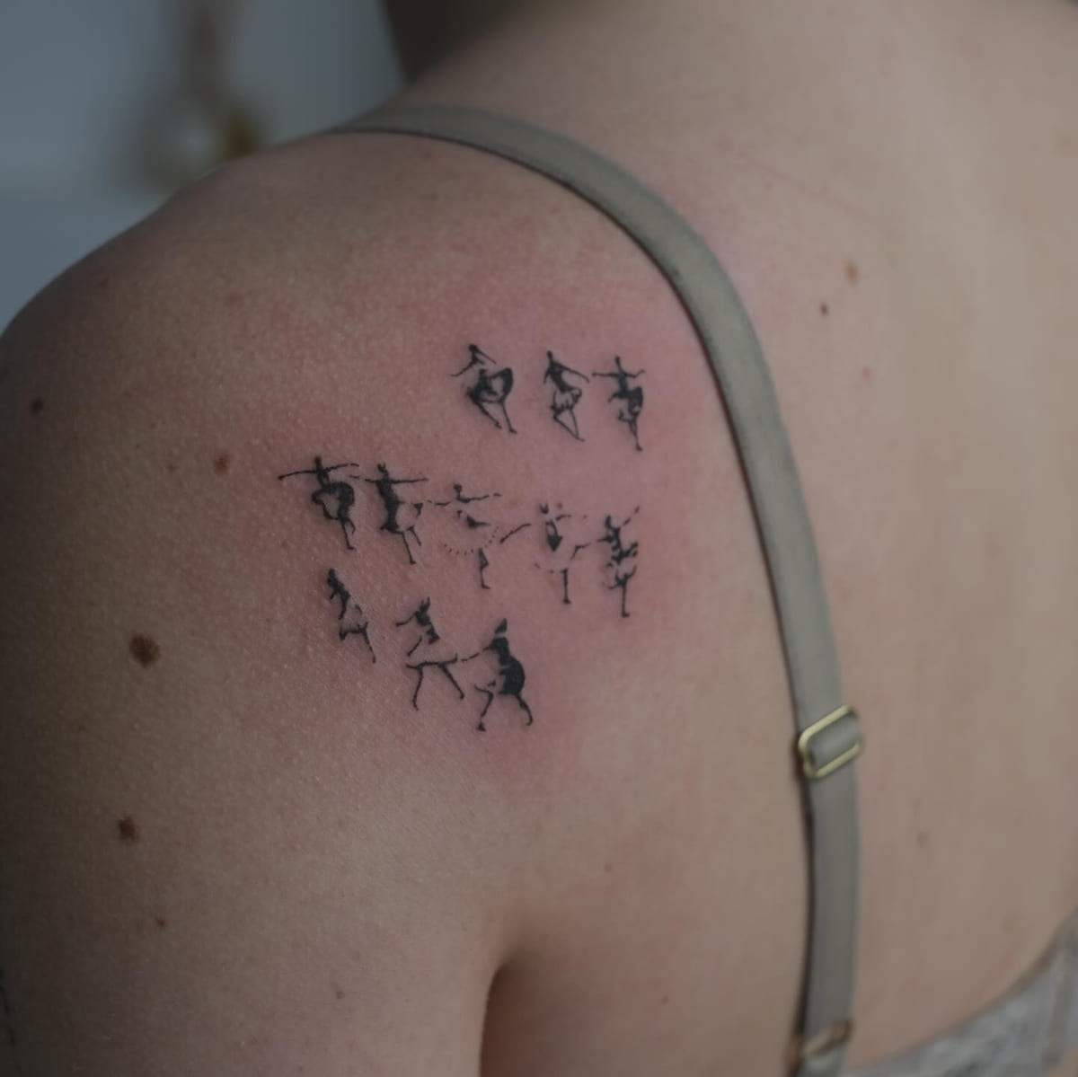 Crowd of tiny dancing figures, fine line tattoo