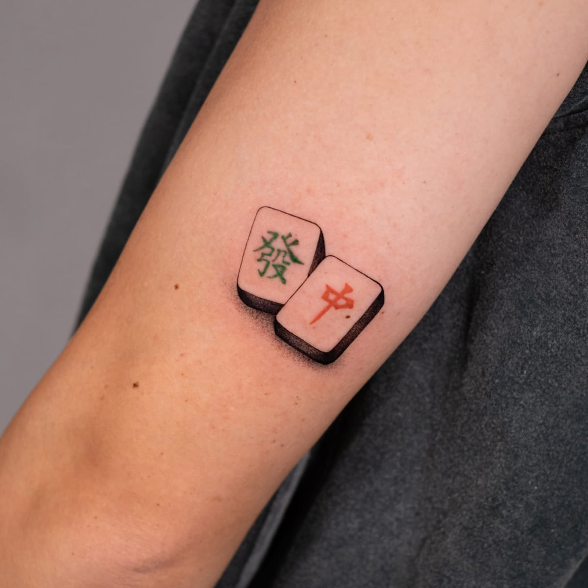 Two mahjong tiles in green and red, realistic, fine line tattoo