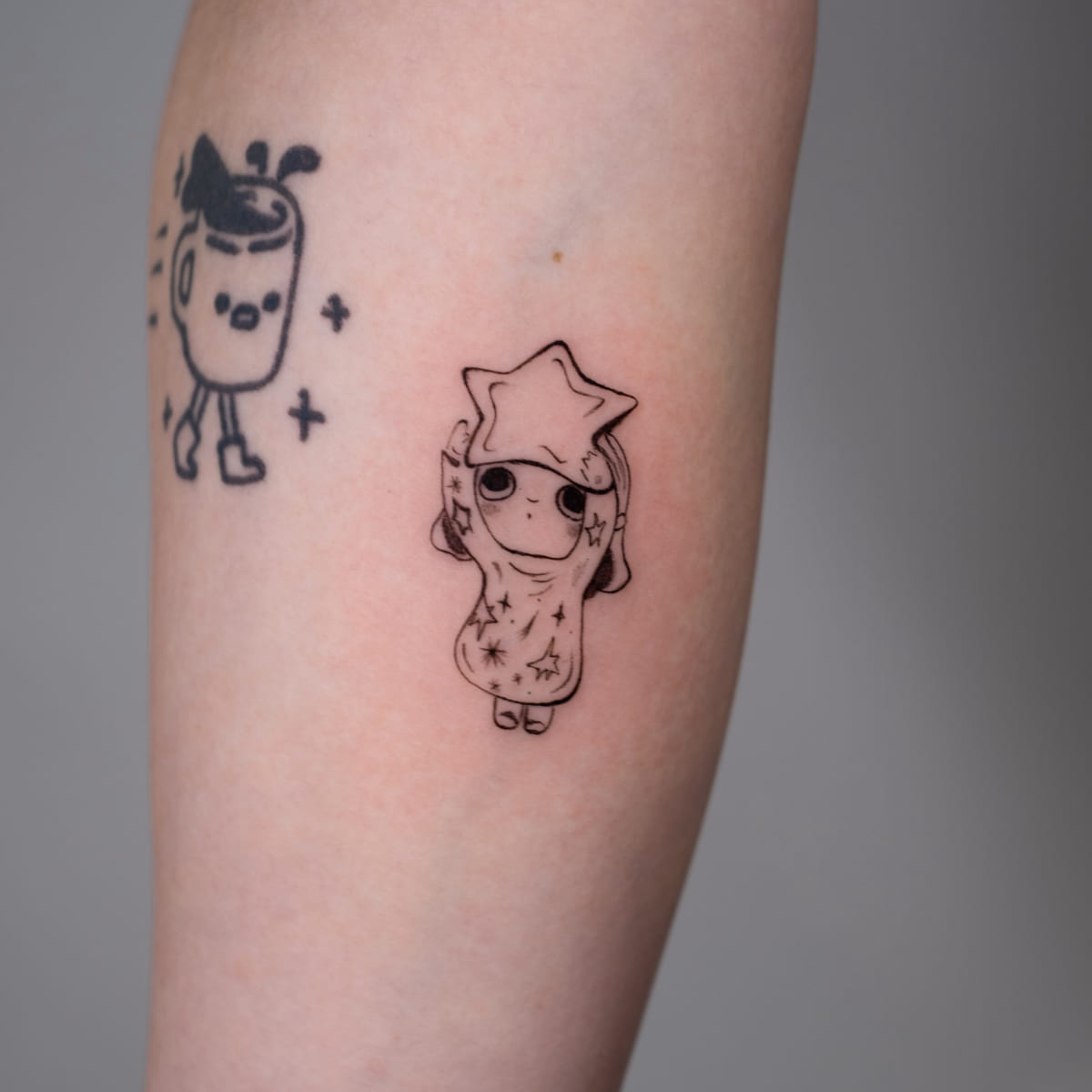 Child in a star hood, fine line tattoo