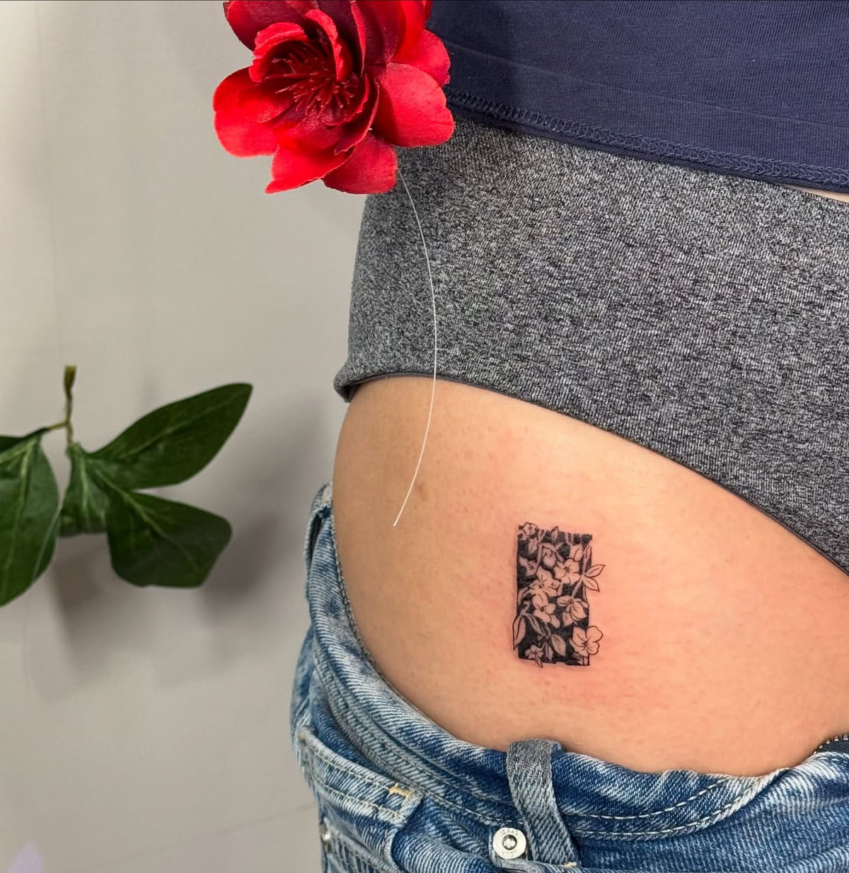 Flowers inside a solid black rectangle, fine line tattoo