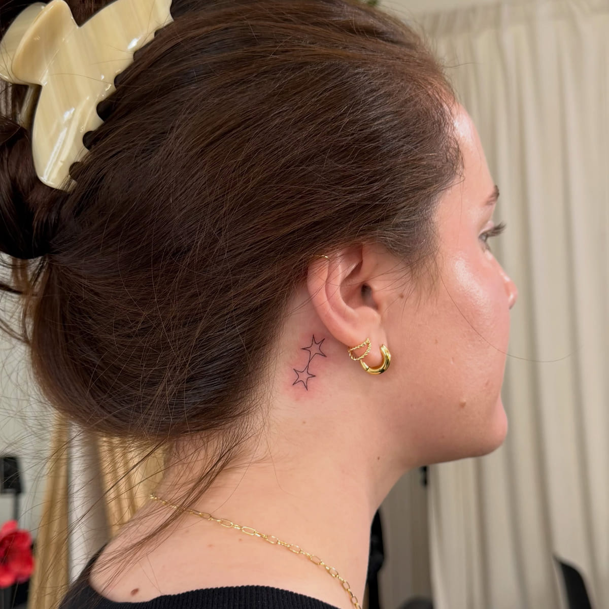 Three tiny stars behind the ear, fine line tattoo