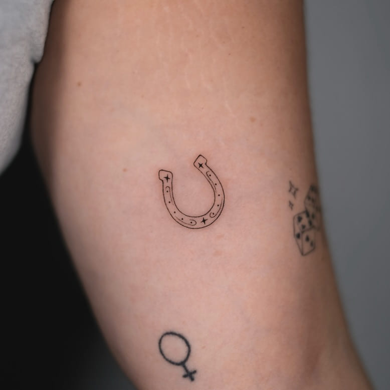 Teeny horseshoe with sparkles, fine line tattoo