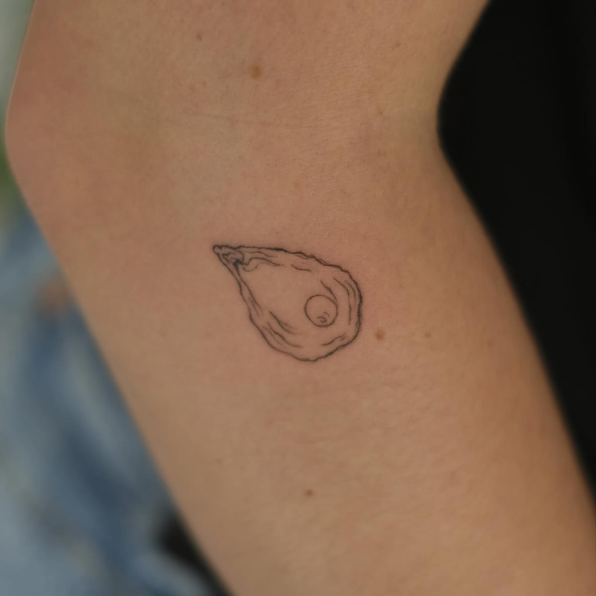 Oyster with a pearl, fine line tattoo