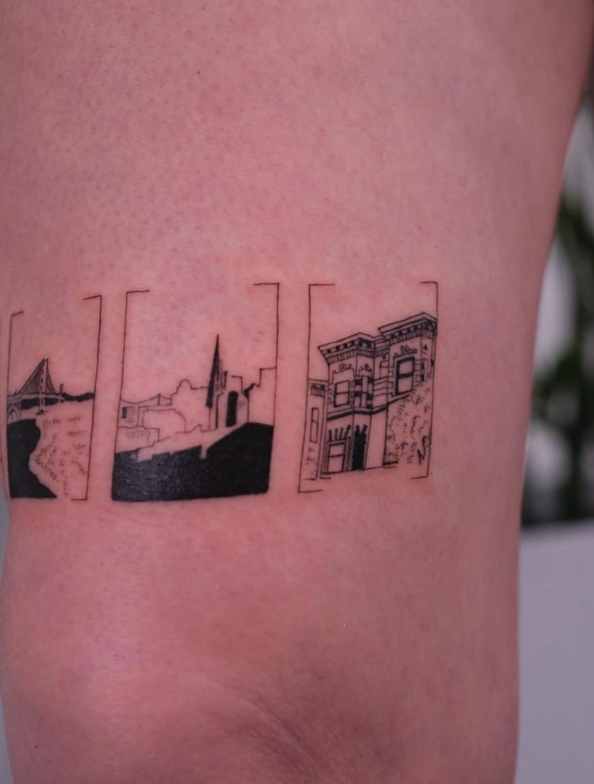 Band of framed San Francisco views above a knee: the bridge, a skyline with a spire, a Victorian house, fine line tattoo