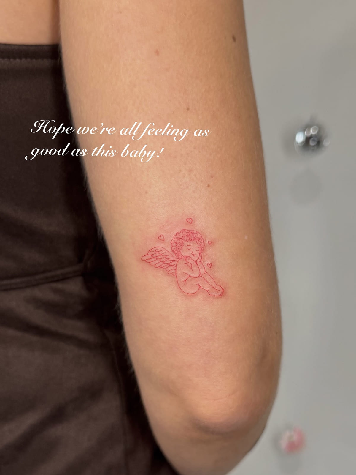 Sleeping cherub in red, fine line tattoo