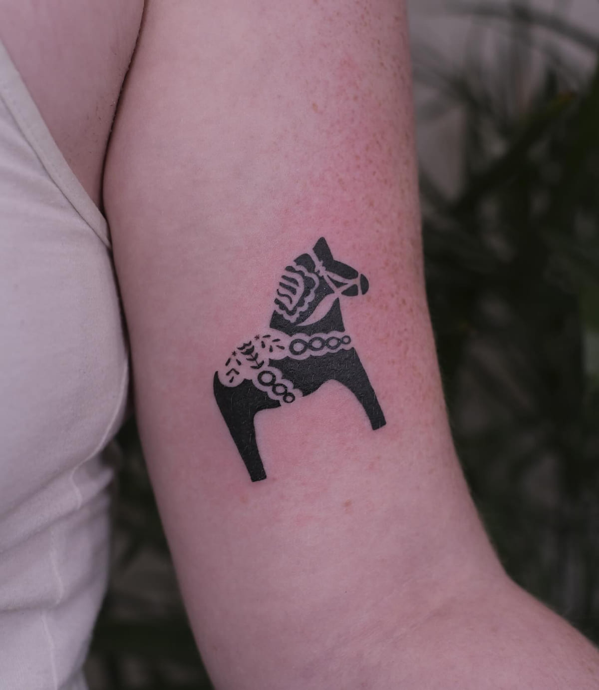 Dala horse in solid black with negative space ornament, fine line tattoo