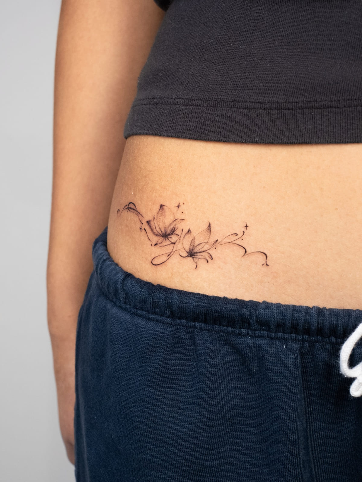 Lilies with flowing tendrils, fine line tattoo