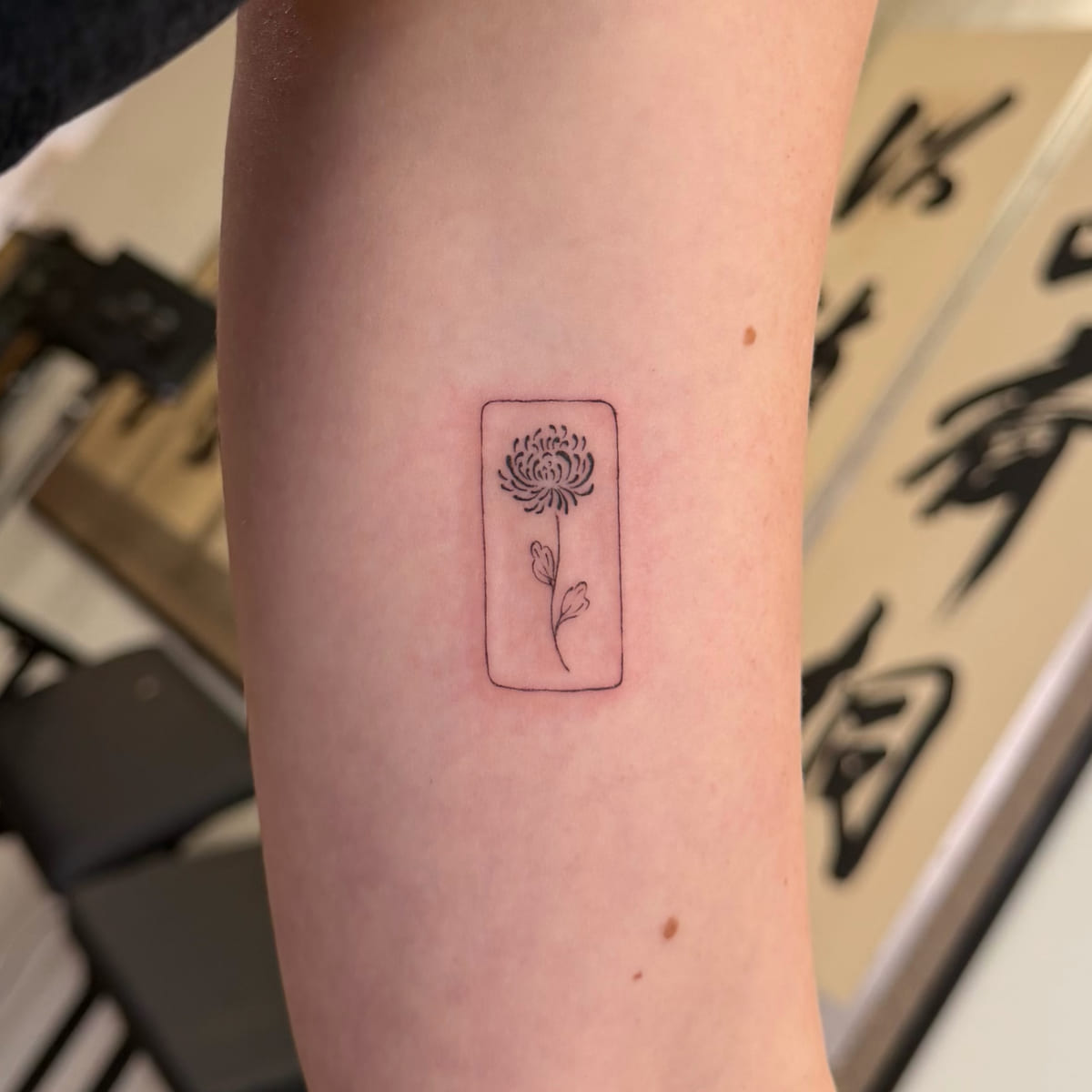 Chrysanthemum inside a tall rectangle, fine line tattoo
