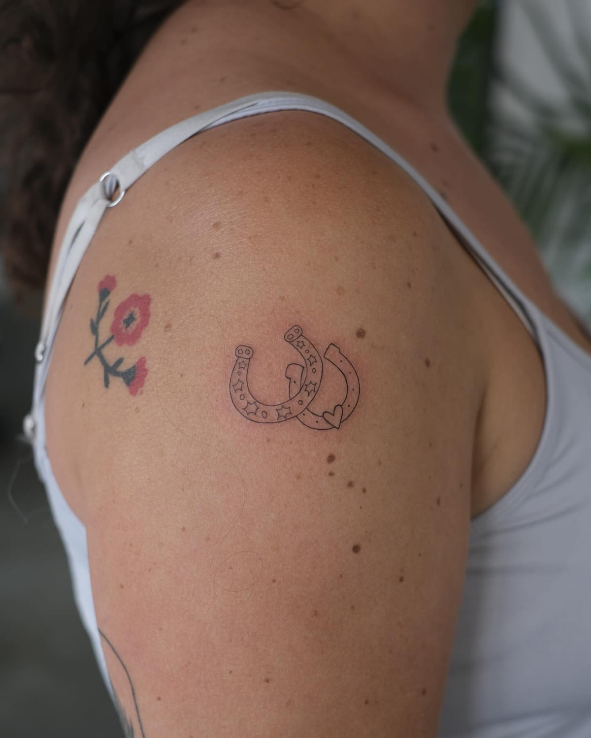 Two linked horseshoes, fine line tattoo