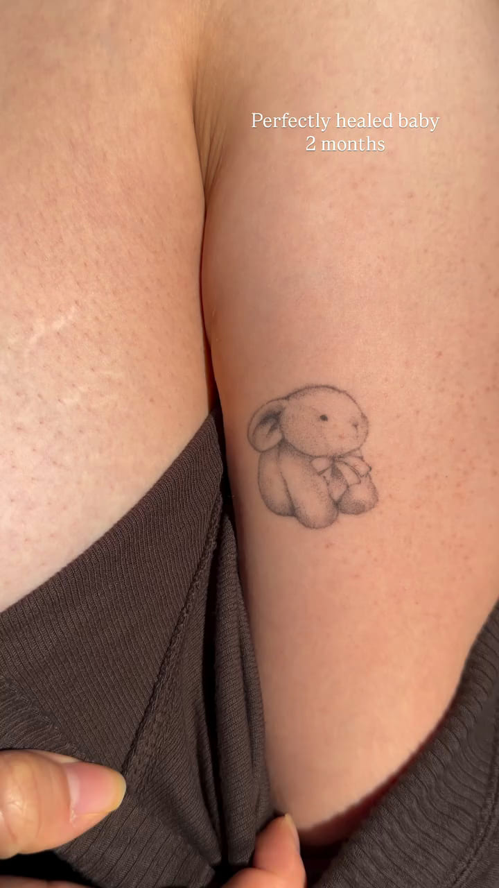 Shaded teddy bear on an upper arm, healed fine line tattoo