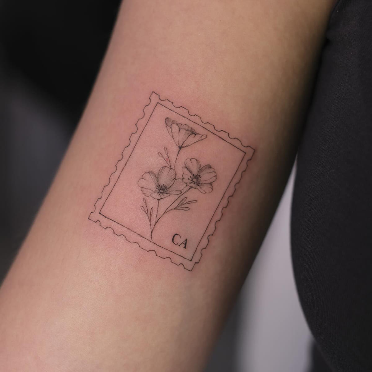 Postage stamp with California poppies and the letters CA, fine line tattoo