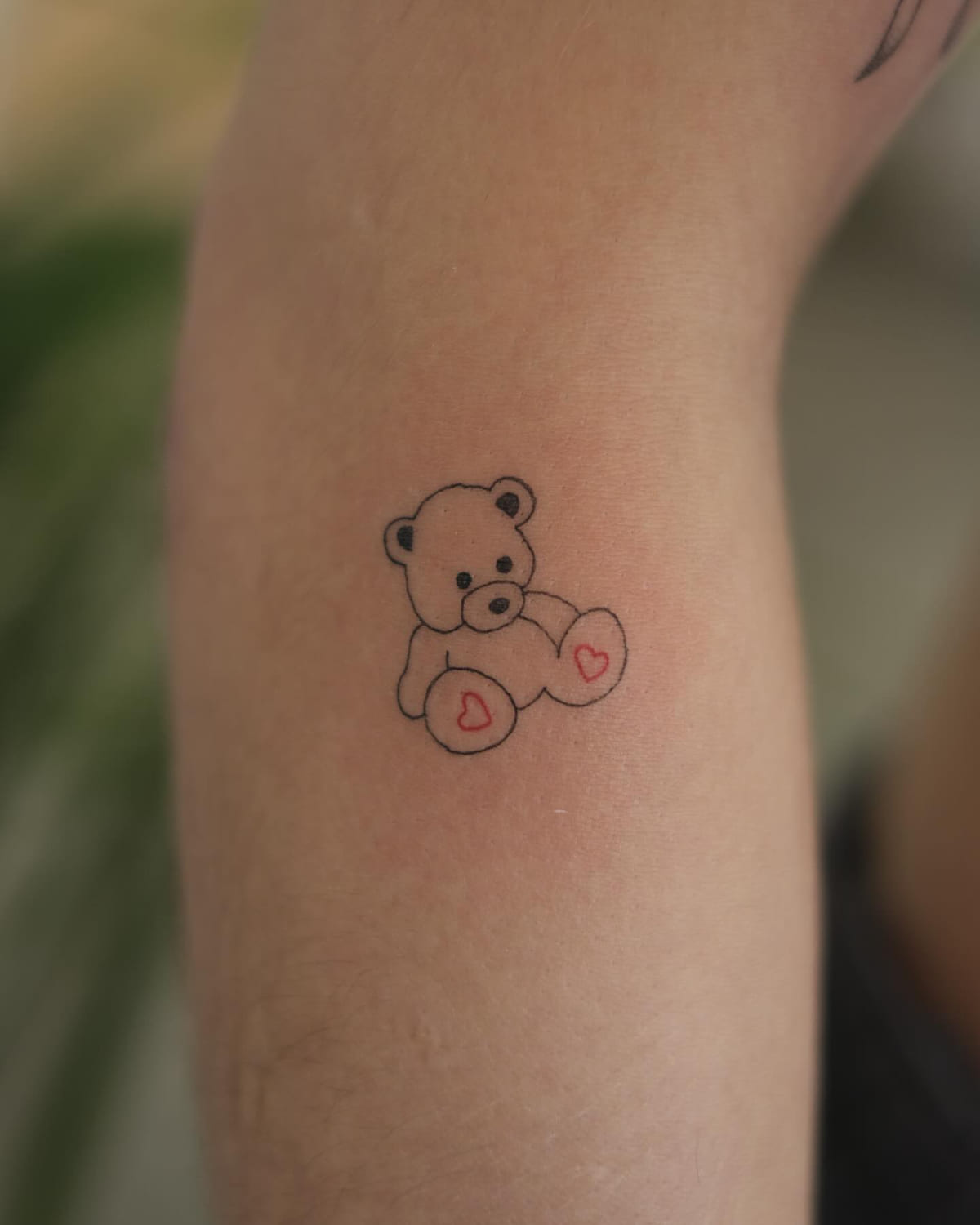 Teddy bear with red heart paws, fine line tattoo