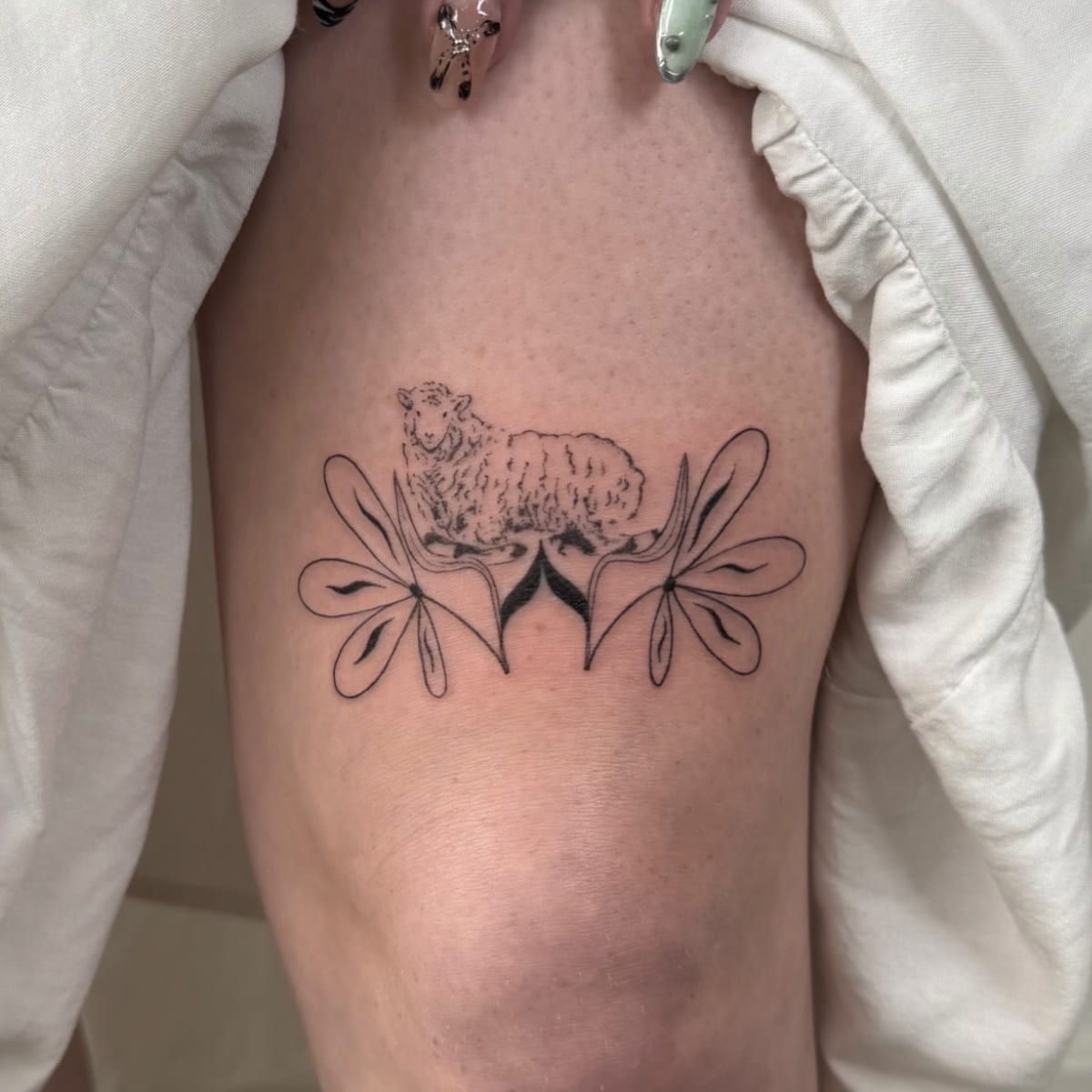 Sheep standing on a symmetrical leaf ornament, fine line tattoo