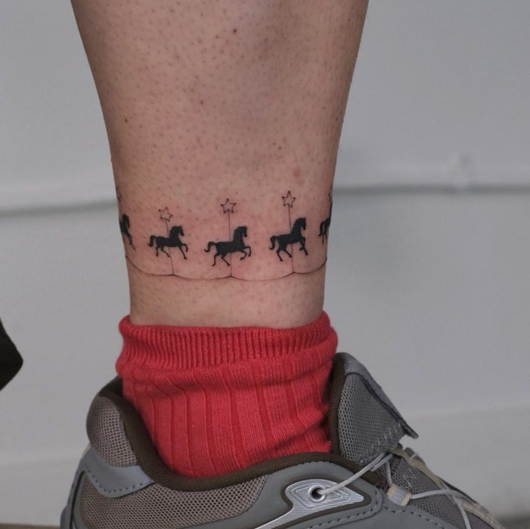 Carousel band of tiny horses and stars around the ankle, fine line tattoo