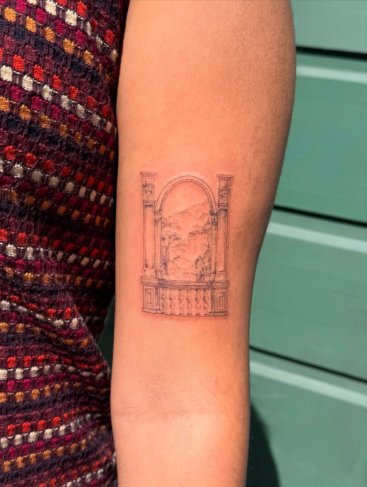 Arched window with columns and balustrade framing a hillside town, another view