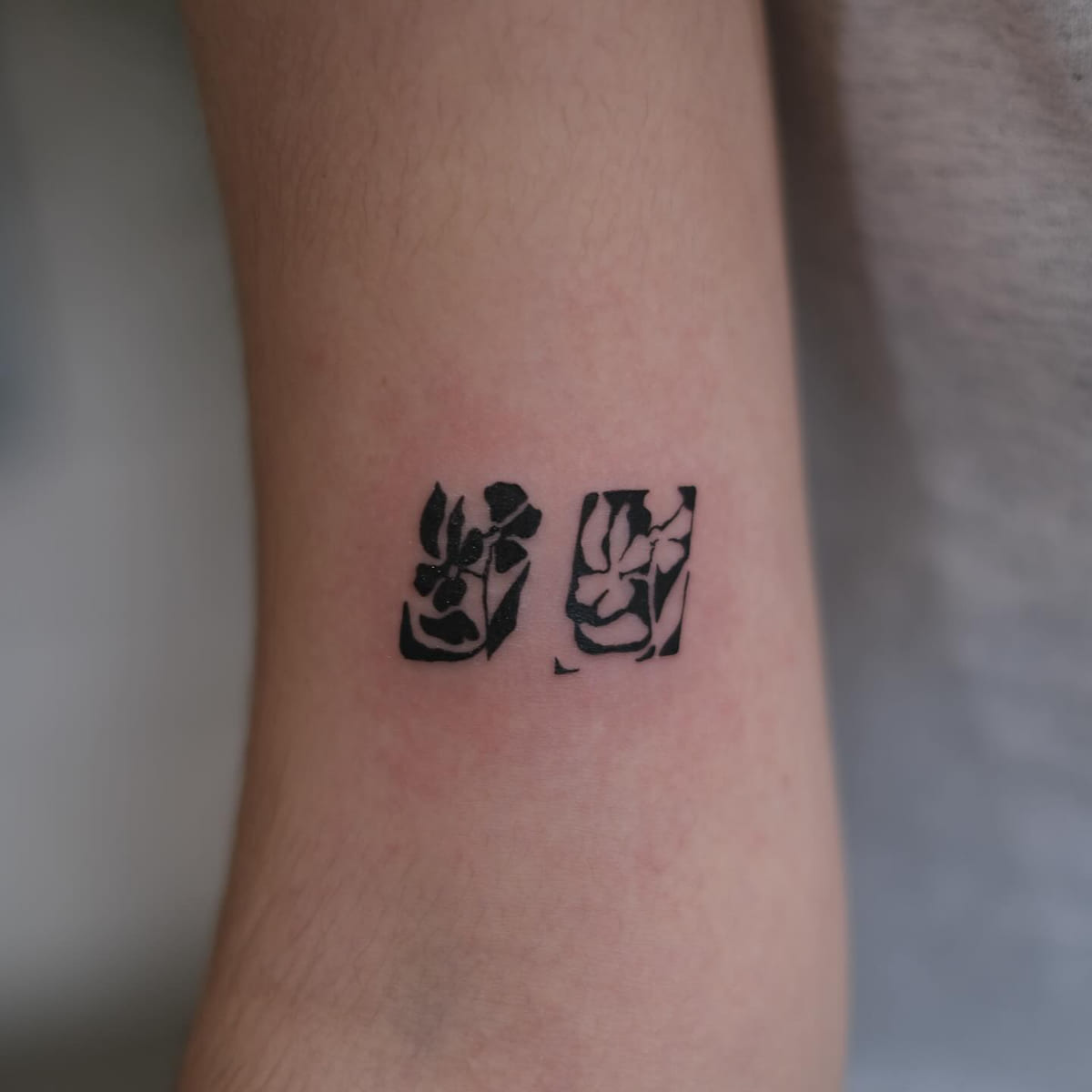 Two solid black flower blocks, fine line tattoo