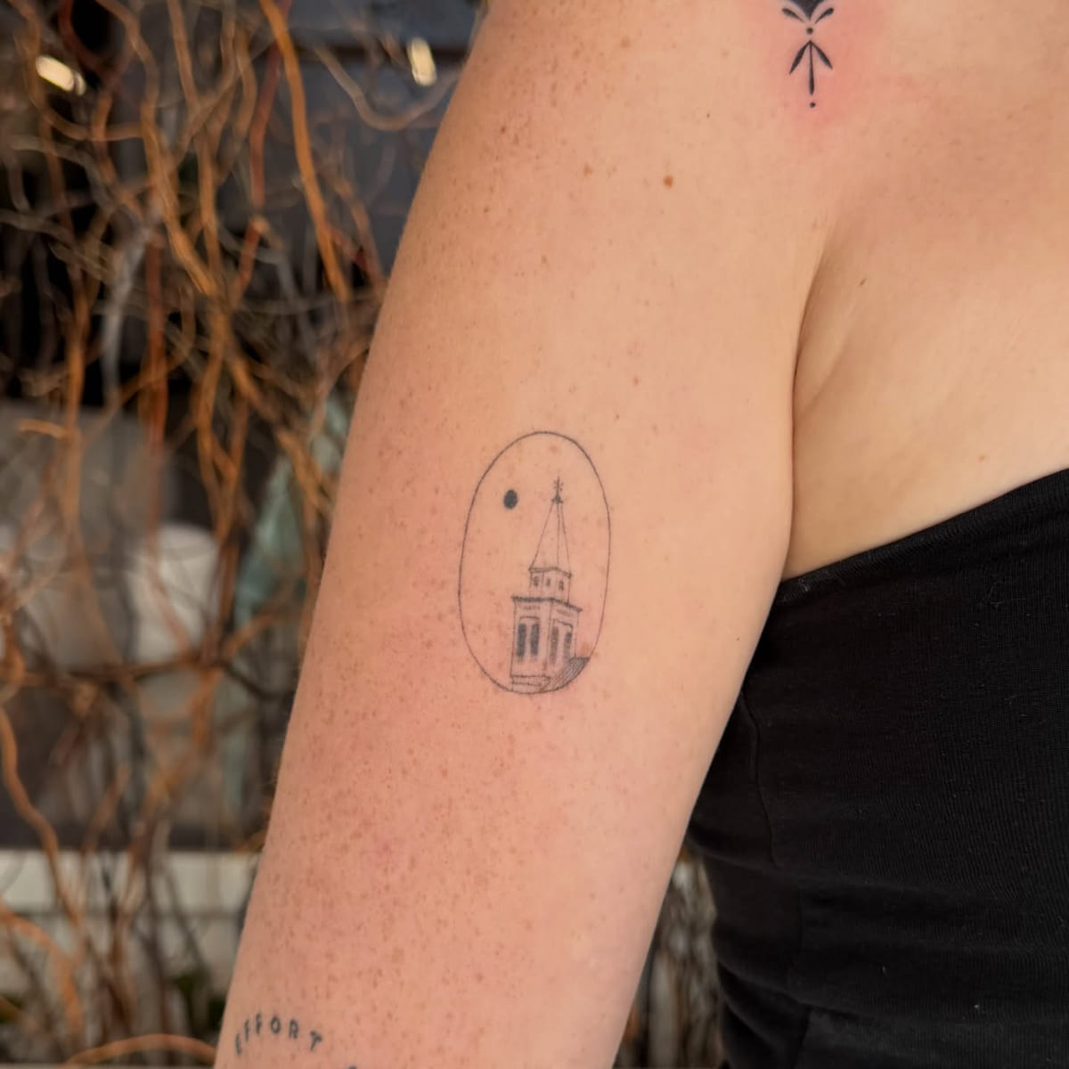 Church steeple and moon inside an oval, fine line tattoo