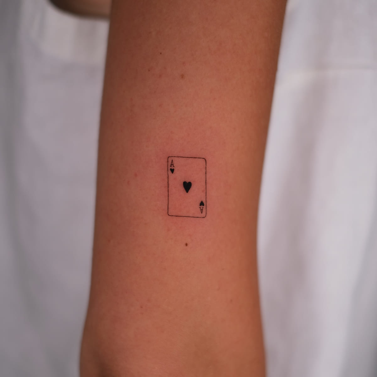 Tiny ace of hearts card, fine line tattoo