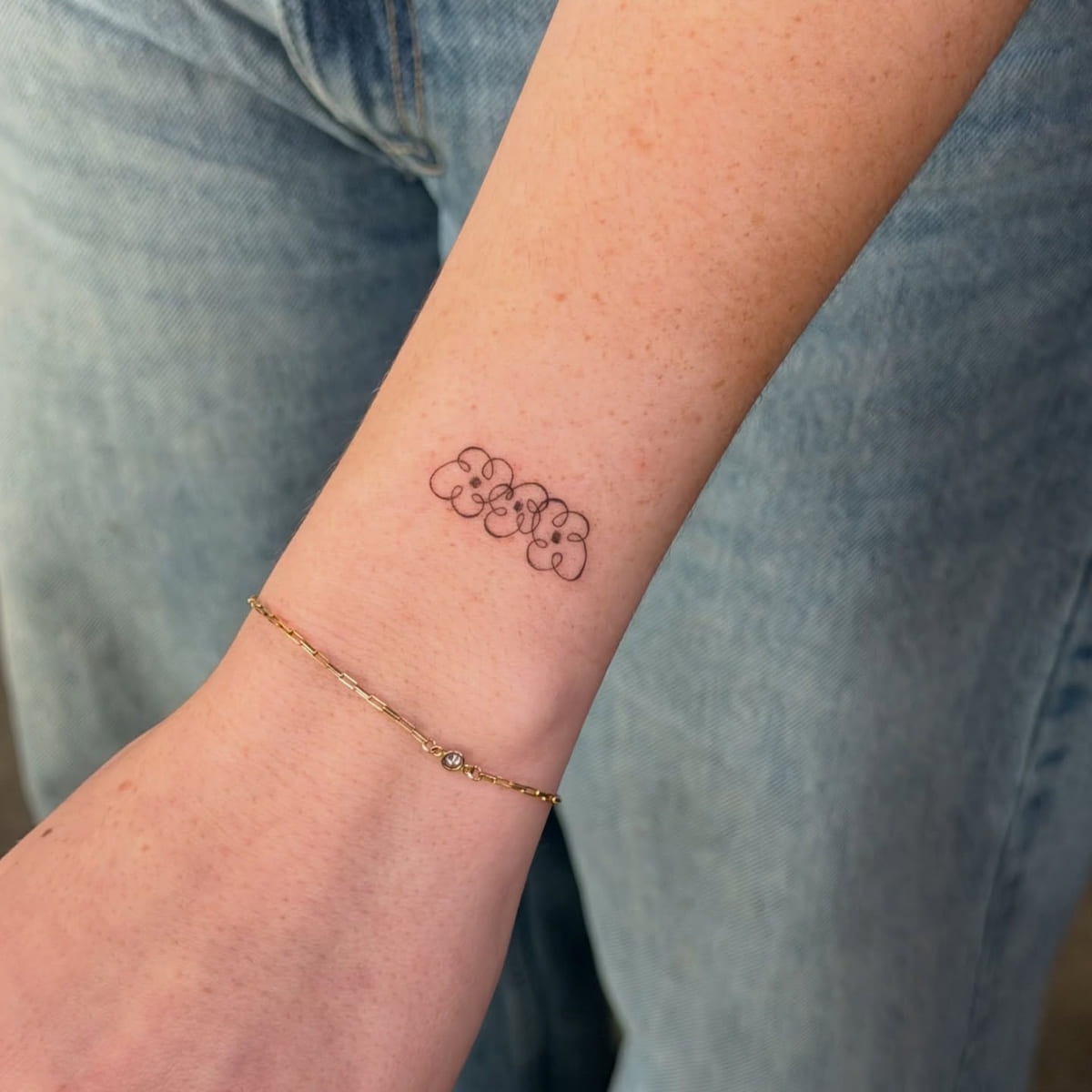 Row of tiny flowers, fine line tattoo